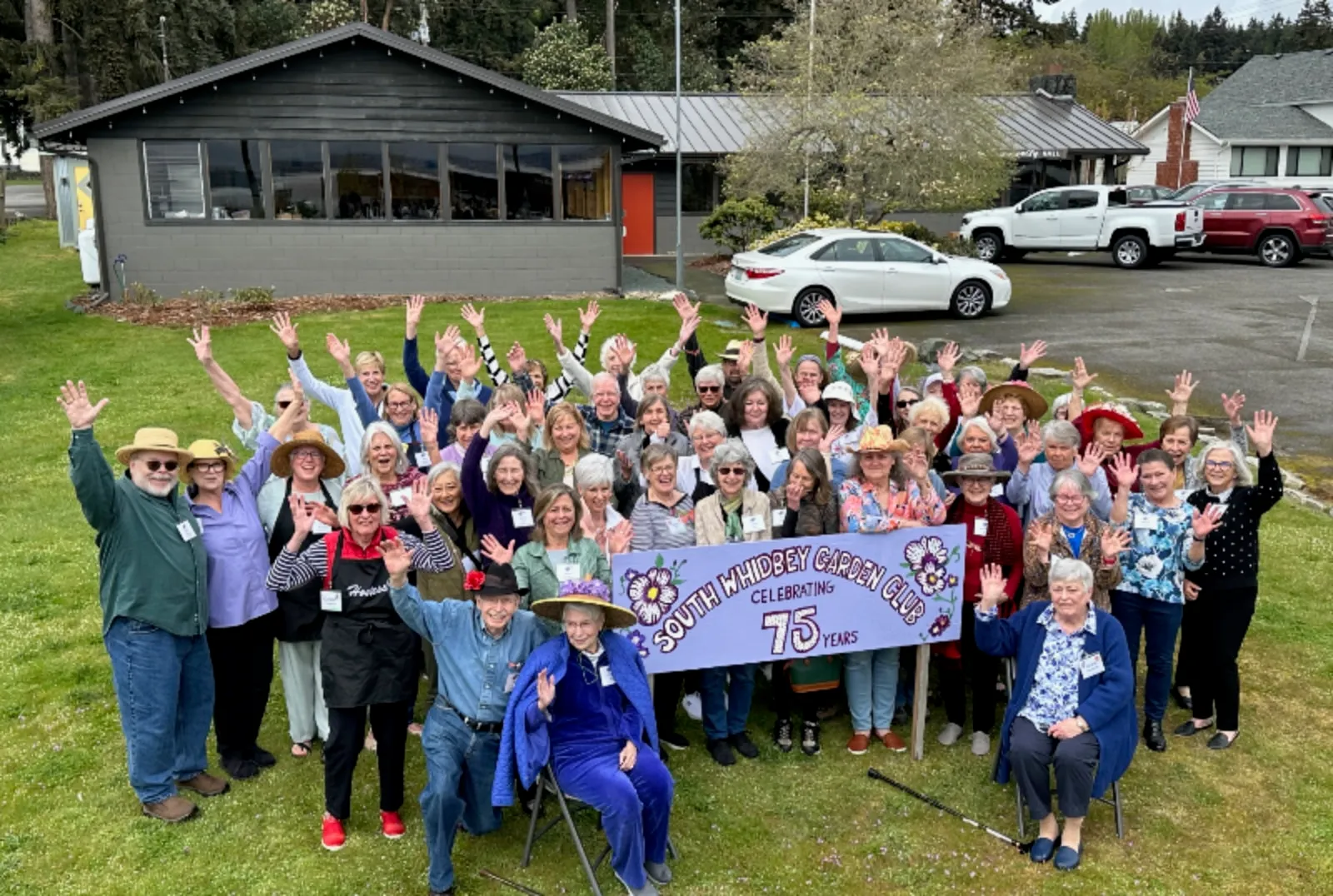 Community members waving in front of the Hall