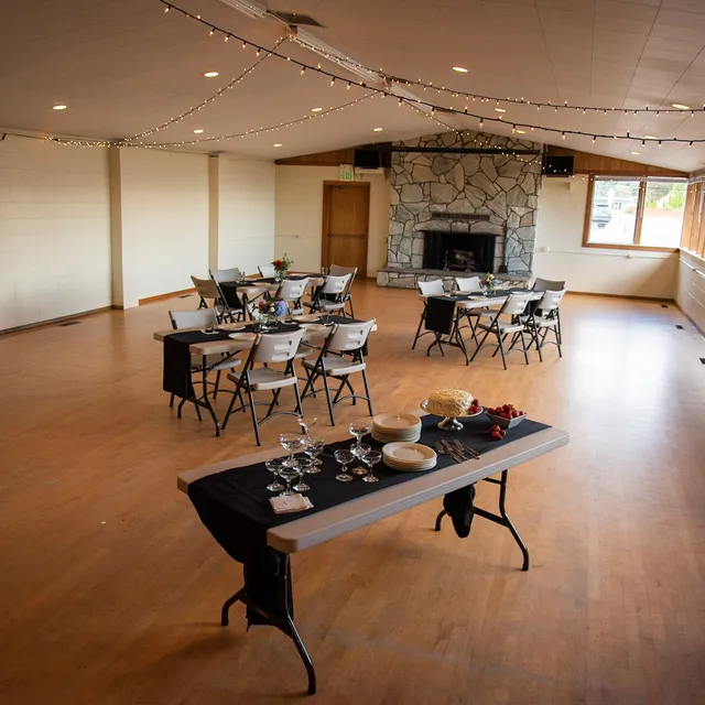 Main hall set with tables and chairs facing the fireplace